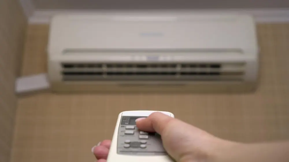 Homeowner adjusting air conditioning